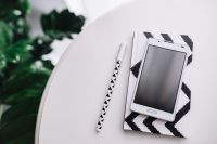 Kaboompics - Black-and-white notebook and a white smarphone with various items