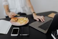 Kaboompics - Businesswoman eats at work hamburger and fries