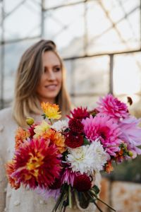 Kaboompics - A woman with beautiful colorful dahlia flowers