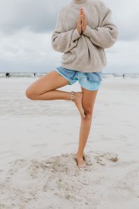 Kaboompics - A young woman on the beach is doing yoga