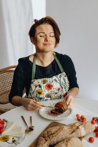 Woman is cutting tomato on plate