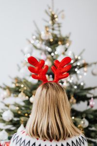 Kaboompics - Woman Wearing Reindeer Horns on Head, Christmas Tree Background