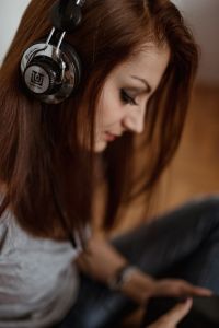 Kaboompics - Beautiful young woman in headphones listening to music