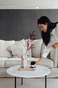 Kaboompics - Marble round table - linen sofa - beige - living room - vase - candle - dries - Asian adult woman