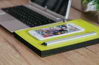 Kaboompics - Silver Acer laptop, a white Apple iPhone and a yellow notebook on a wooden desk
