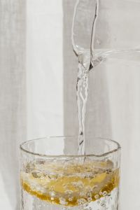 Kaboompics - Lemon slice in a glass of water - pouring