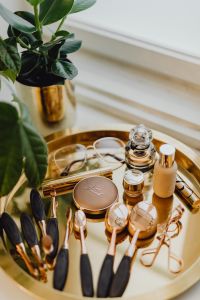 Kaboompics - Makeup essentials on a golden tray
