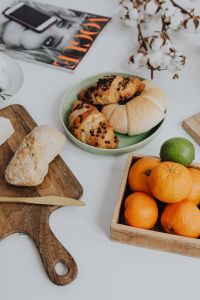 Orange - croissant - cutting board ona table