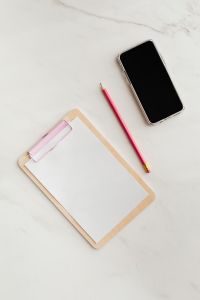 Kaboompics - Clipboard on a marble table, a mobile phone and a pencil, copy space