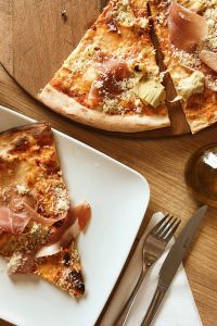 Kaboompics - Pizza with Prosciutto on the white plate
