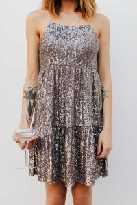 Kaboompics - Blond Woman in a Sequin Dress is Holding a Glass of Champagne, White Background