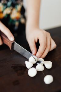 Kaboompics - Teen Girl cuts garlic