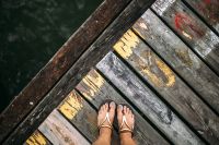 Detail of the legs of a woman standing at the edge of the pier