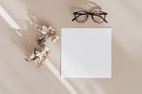 Blank card & glasses on beige background