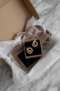 Kaboompics - Minimalist UGC-Inspired Jewelry Display on Marble Surface with Elegant Packaging