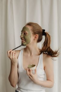 Kaboompics - Young Woman Applying Green Clay Mask to Her Face