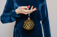 Woman in Blue Blouse Holds a Christmas Tree Bauble