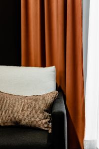 Kaboompics - Grey armchair and pillow - orange curtain