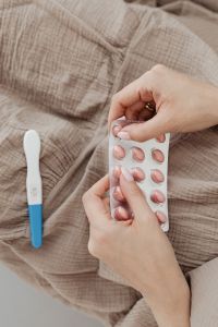 Pregnant Woman Taking Vitamin Pills - positive pregnancy test