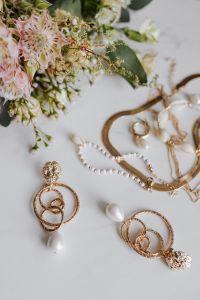 Kaboompics - Gold jewellery on white marble - necklace, bracelets, earrings, flowers