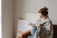 Kaboompics - Cocooning - isolating yourself - stay at home - woman under a blanket - reading a book