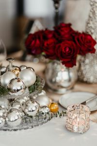 Kaboompics - Silver Christmas tree balls on the stand, candle holder and red roses in a silver vase on the table