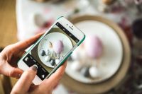 Woman taking photo of easter eggs on a plate
