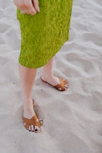 Kaboompics - A woman in a green dress and leather shoes on sand