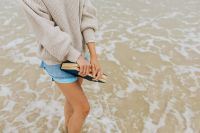 Kaboompics - A young woman with a book on the seashore