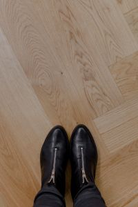 Kaboompics - The woman in black leather shoes is standing on the oak floor