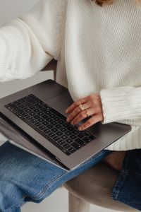 Kaboompics - Woman in white sweater - gold rings - jewelry - jeans - laptop - work