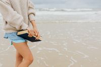 A young woman with a book on the seashore