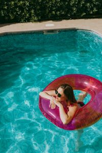 A beautiful woman in a pool with an inflatable ring