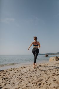 Woman jogging on the beach - running