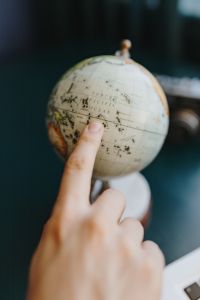 Male Finger Showing A Part Of The World On An Globe