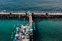 Pier with umbrellas at the seaside, Sorrento beaches, Italy