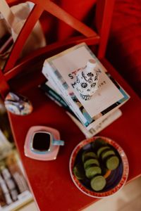Kaboompics - Coffee, Green Tea Cookies, Books on the Red Chair