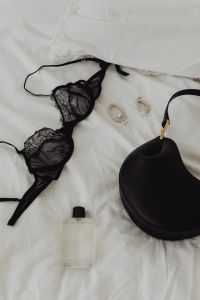 Kaboompics - Black lace underwire bra and panties - perfume - silver earrings - white sheets on the bed - black leather bag