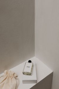 Stylish UGC-Influenced Perfume Bottle on White Surface with Textured Background - Chic Free Stock Photo