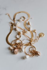 Kaboompics - Gold jewellery on white marble - necklace, bracelets, earrings