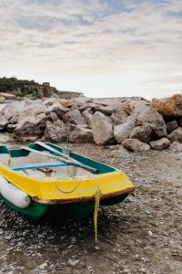 Kaboompics - Little yellow green boat on the beach