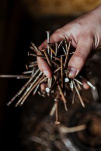 Kaboompics - Man grabbing a heap of rusty nails