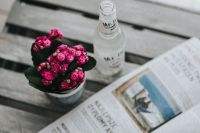 Kaboompics - Little pink flowers with a bottle of water and a magazine