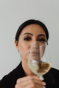 Kaboompics - Sophisticated Wine Tasting Portraits - Modern Asian Woman in Elegant Black Outfit Holding White Wine Glass