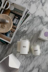 Kaboompics - Luxurious Scented Candles on Marble Surface with Lifestyle Magazine - UGC Style Home Decor Photography