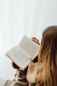 Kaboompics - A young girl reads a book