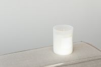 Kaboompics - Candle in white glass with label on linen couch