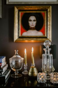 Kaboompics - Decanter, candles, and a painting on the wall