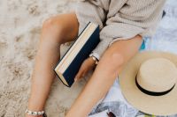 A woman reads on the beach in the summer