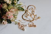 Kaboompics - Gold jewellery on white marble - necklace, bracelets, earrings, flowers